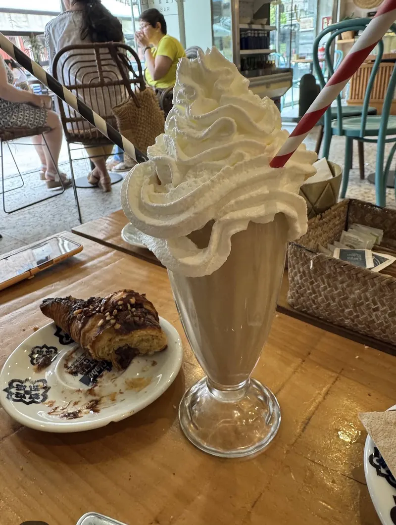 Batido con nata montada y un croissant relleno de chocolate