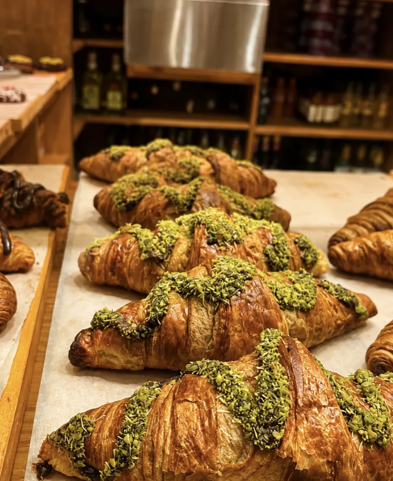 Croissants con cobertura verde alineados en el mostrador de Valentina