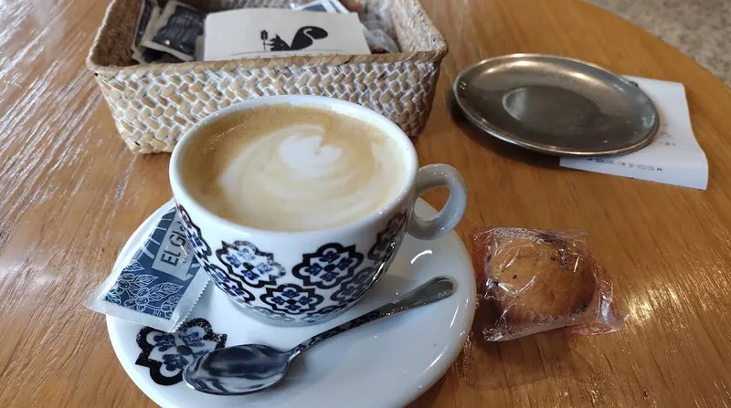 Café con leche en taza azul y blanca sobre la mesa