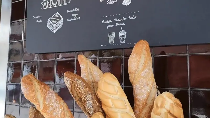 Panes y baguettes en cestas, sobre azulejo rojizo