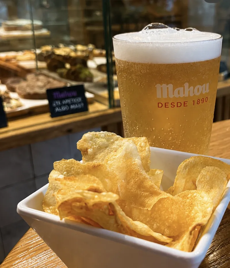 Caña de cerveza fría con un cuenco de patatas fritas